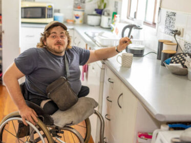 Disabled Man Making Cup Of Tea In The Kitchen